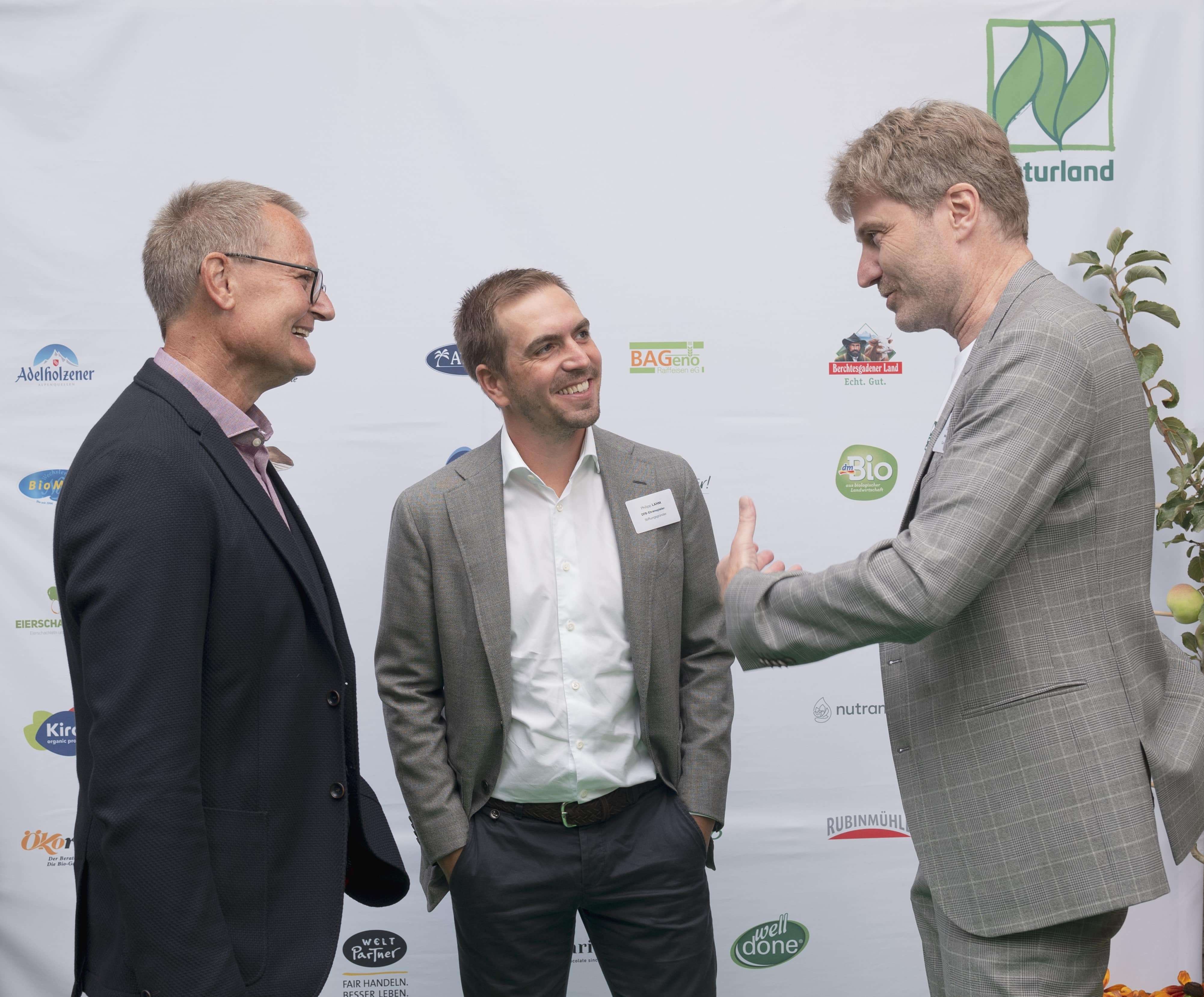 Philipp Lahm gratuliert Naturland-Präsident Hubert Heigl (links) und Geschäftsführer Steffen Reese zum 40-jährigen Naturland-Jubiläum.